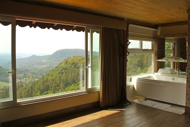 quarto com banheira e cama de frente para a vista do Vale