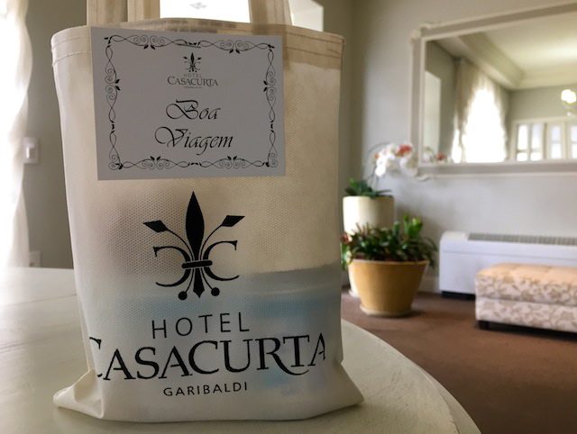 A sacolinha fofa demais com Kit de Boa Viagem que os hóspedes recebem na partida: maças e água para viagem. Amei